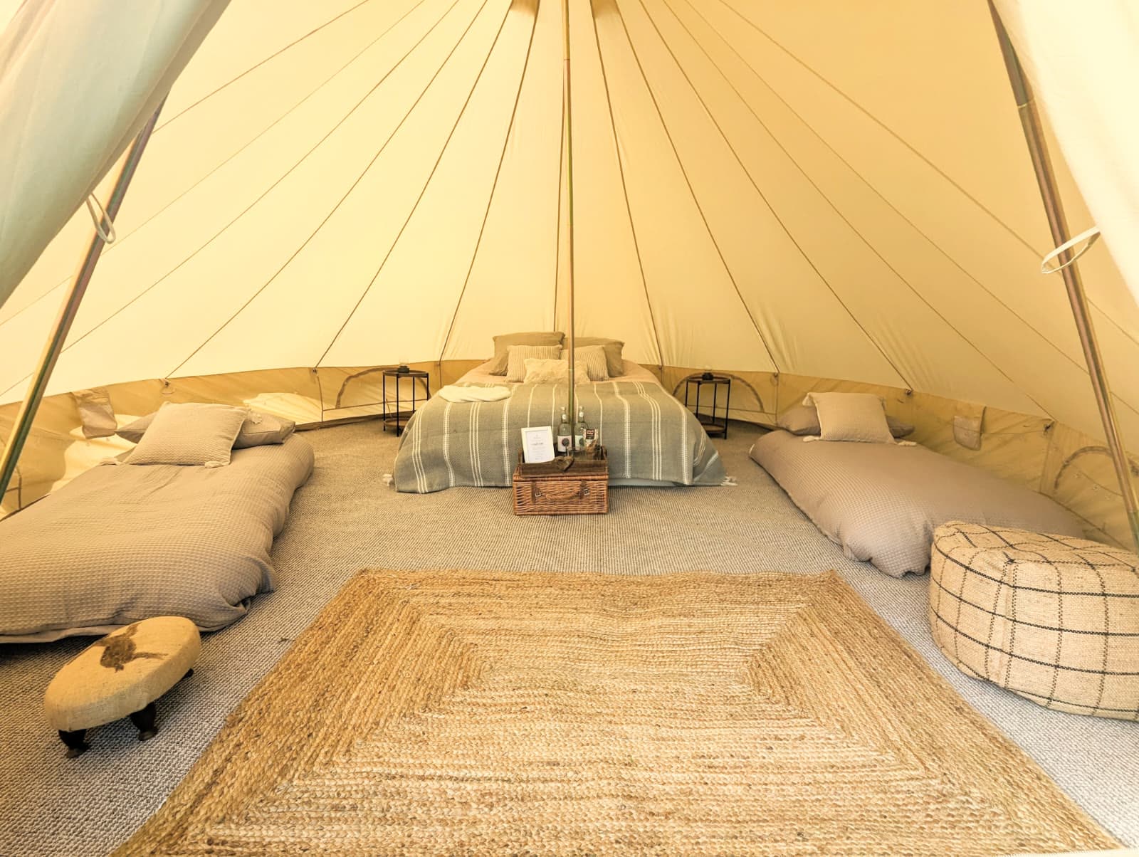 Custom Camp Chic family bell tent interior with king size bed and single air beds for a private event