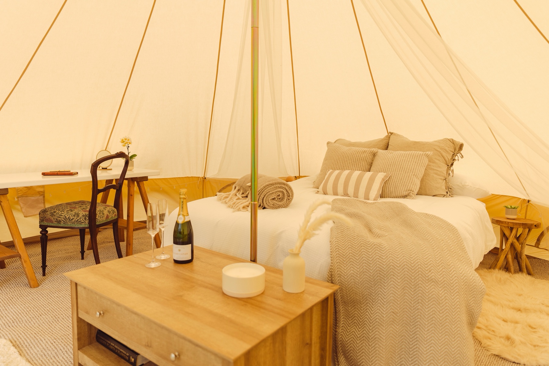 Camp Chic Honeymoon Suite bell tent bed decorated with rose petals for a wedding couple