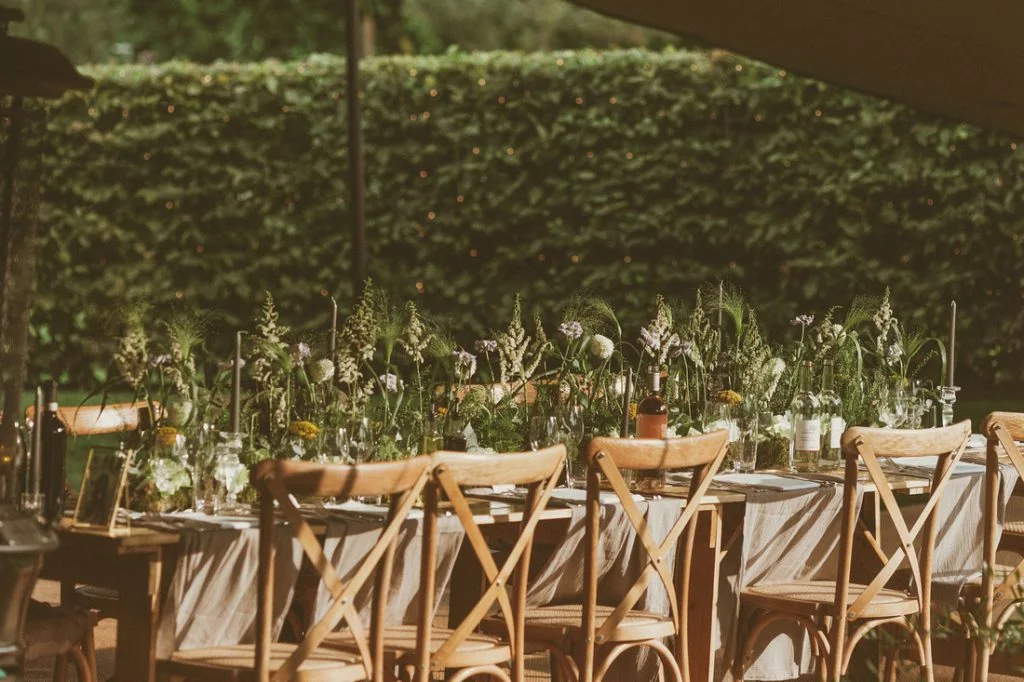 Rustic wedding tables beneath a stretch tent