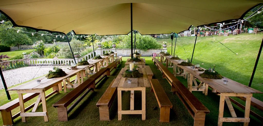 Long dining tables beneath a stretch canopy