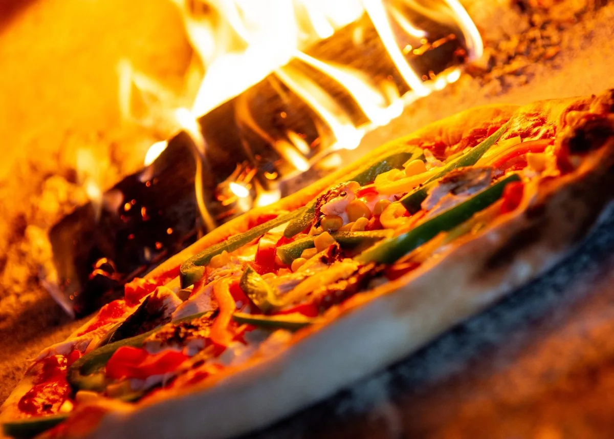 Pizza baking in a wood-fired oven