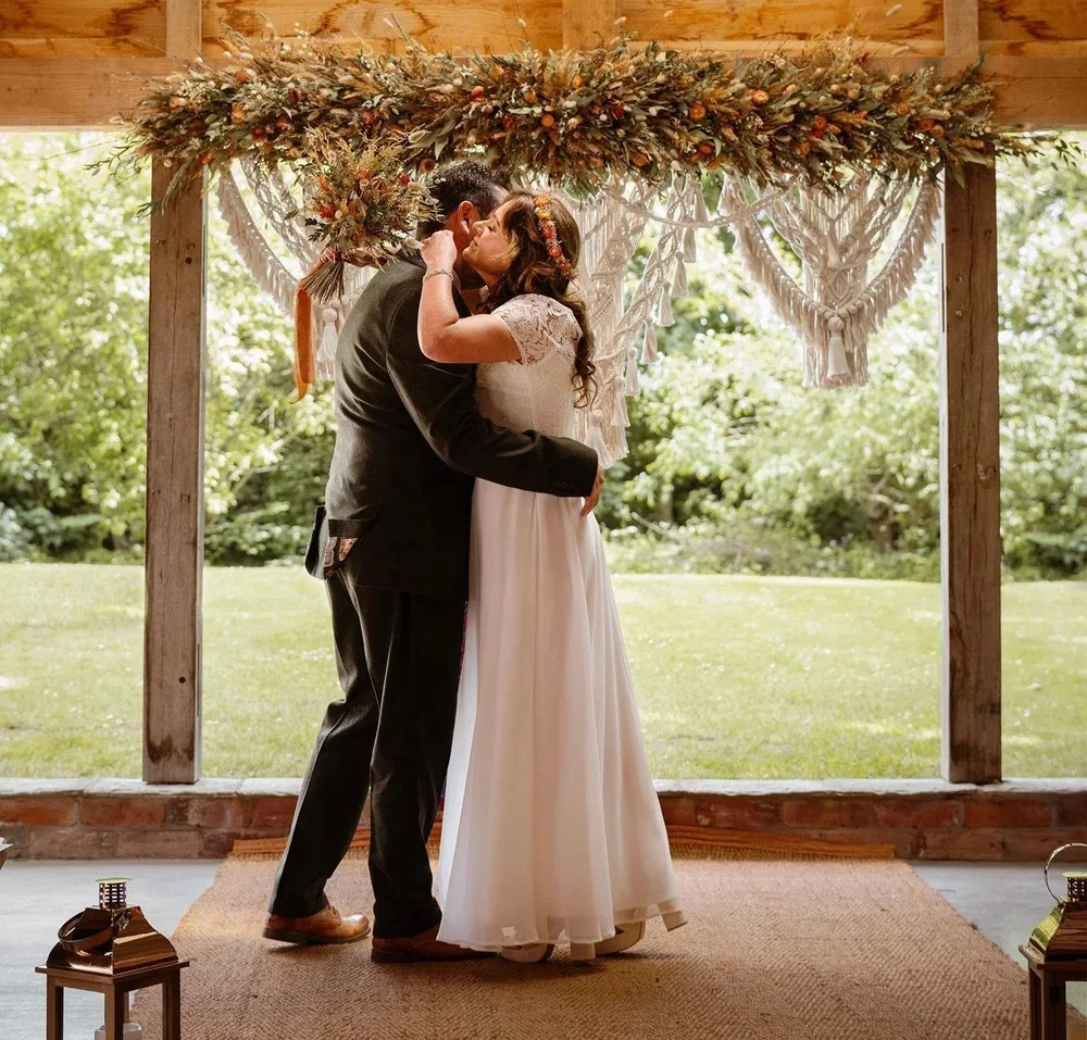 Wedding couple beneath a floral installation